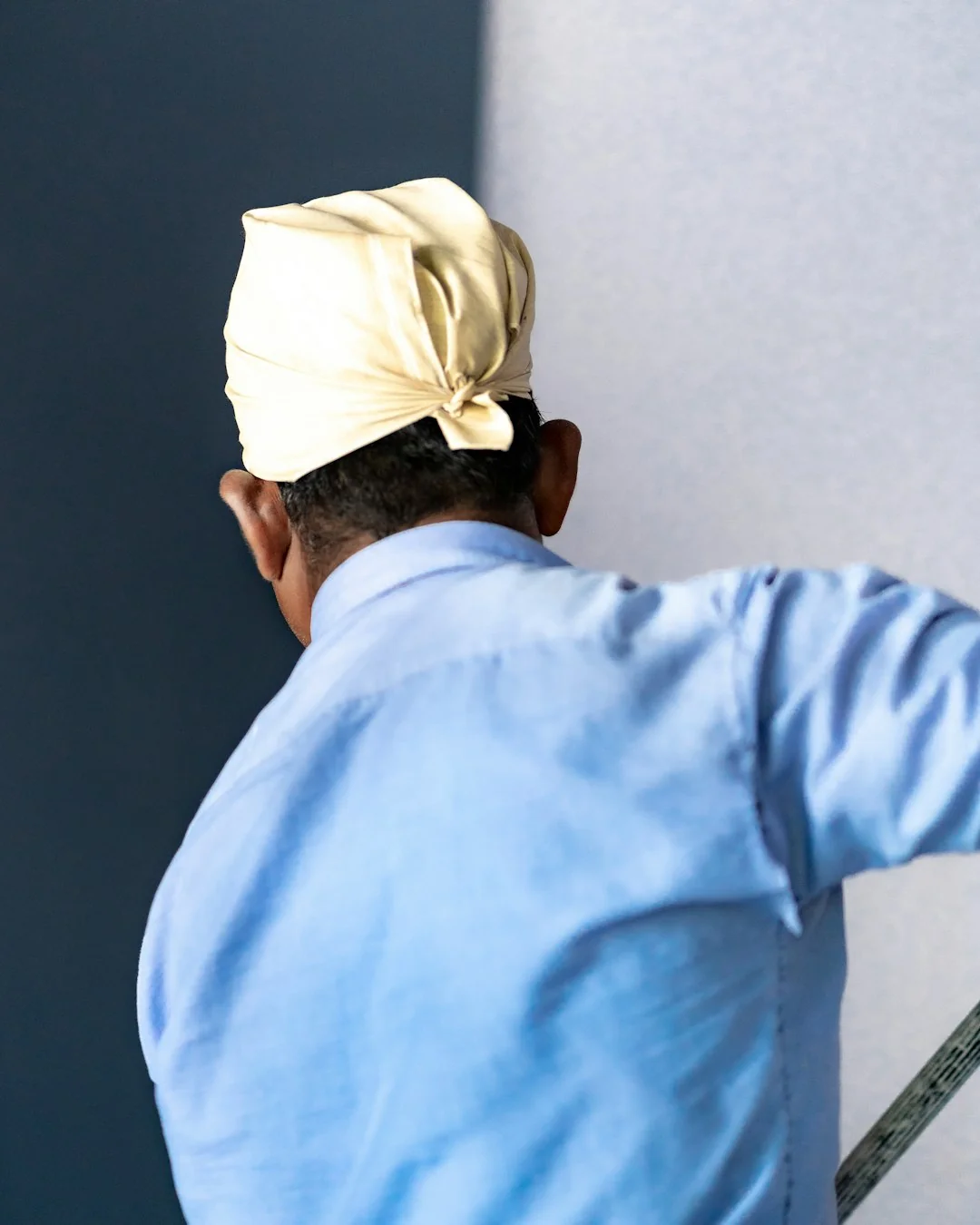 An individual disinfects a workspace using fumigation, wearing full protective gear for safety.
